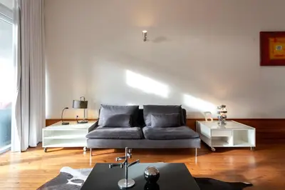 a living room with a couch and a table at Fontainhas Flat: Balcony & Parking in Porto