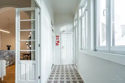 a hallway with a white door and a tile floor at Nomad's Family - 3BDR Charming Hideouts Porto in Porto