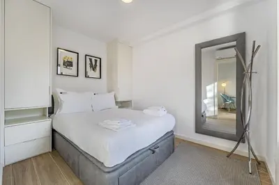 a white bedroom with a bed and a mirror at Nomad's Lux - 1BDR The Silent Nest in Bonfim in Porto