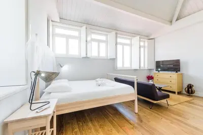 a bedroom with a bed and a desk and a chair at Frei Yellow Studio in Porto