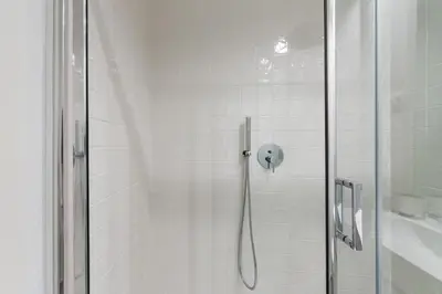 a shower with a glass door in a bathroom at Frei Yellow Studio in Porto