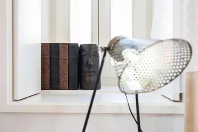 a chair in front of a window with books at Frei Yellow Studio in Porto