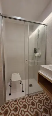 a glass shower in a bathroom with a sink at ALMARELA apartments in Porto