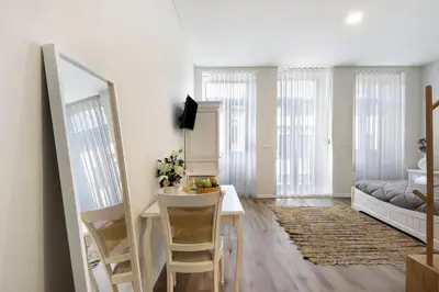 a living room with a desk and a bedroom at Porto Bello - Apartamento - 3 in Porto