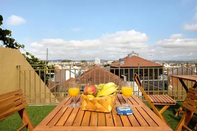 a wooden table with a basket of fruit and glasses of orange juice at Porto Bello - Apartamento - 6 in Porto