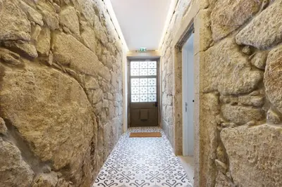 a hallway with a stone wall and a door at Porto Bello - Apartamento - 6 in Porto