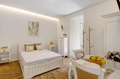a white bedroom with a bed and a table at Porto Bello - Apartamento - 8 in Porto