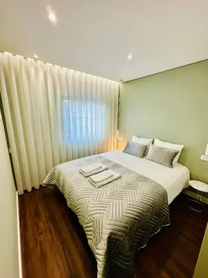 a bedroom with a large bed with a window at House Real Companhia 55/53 in Vila Nova de Gaia