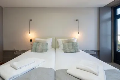 a bedroom with a bed with two towels on it at Cedofeita's Blue House in Porto
