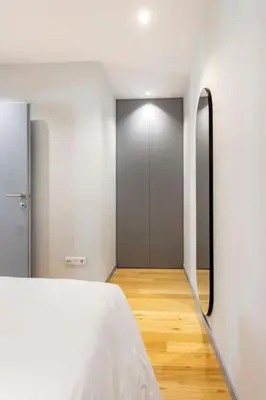 a room with a bed and a hallway with a mirror at Almada 505 City Center Duplex in Porto
