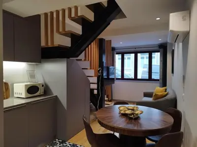 a small living room with a table and a kitchen at Almada 505 City Center Duplex in Porto