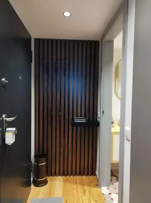 a bathroom with a wooden door in a room at Almada 505 City Center Duplex in Porto