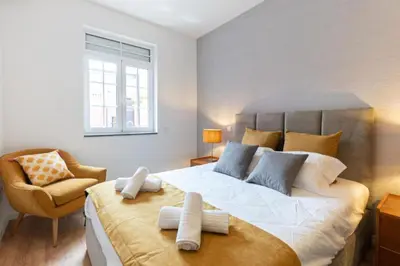 a bedroom with a large bed and a chair at Dellarose Max in Porto
