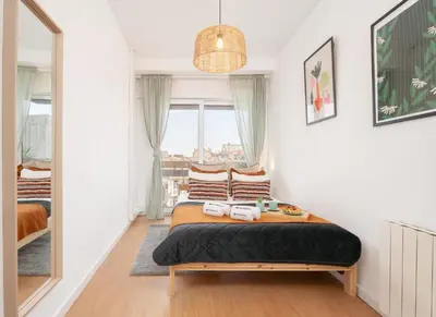 a bedroom with a bed and a large window at Host Wise - Spacious Modern Flat w Balcony in Porto