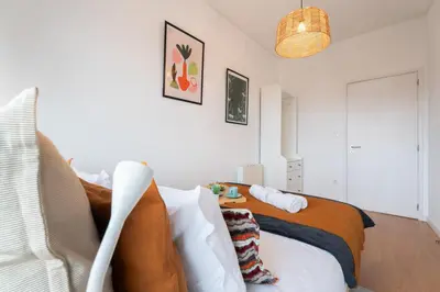 a bedroom with a bed and a chair in it at Host Wise - Spacious Modern Flat w Balcony in Porto