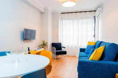 a living room with a blue couch and a table at Emotions Trindade Flat in Porto