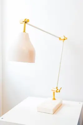 a desk lamp with a white and goldinylietyietyietyietyietyiety tables at Emotions Trindade Flat in Porto