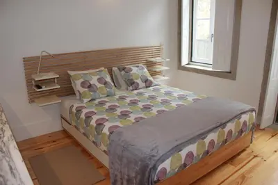 a bedroom with a bed with a wooden headboard at Flower 45 Suite @ Rua das Flores in Porto