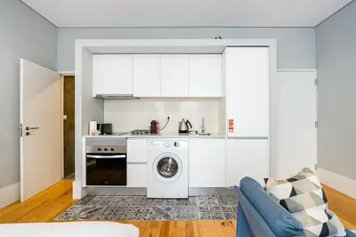 a kitchen with a washing machine in a living room at GuestReady - Comfortable Retreat in Porto in Porto