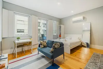 a bedroom with a bed and a couch and a desk at GuestReady - Comfortable Retreat in Porto in Porto