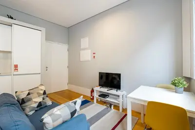 a living room with a blue couch and a table at GuestReady - Comfortable Retreat in Porto in Porto