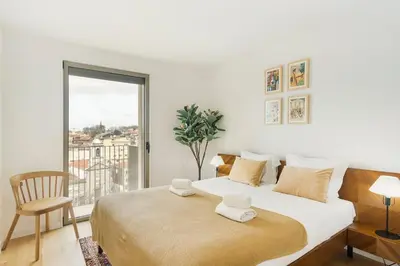 a white bedroom with a large bed and a window at GuestReady - Central Park in Porto in Porto