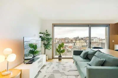 a living room with a couch and a large window at GuestReady - Central Park in Porto in Porto