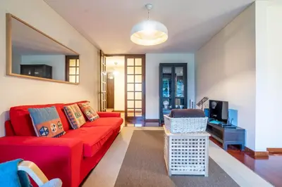 a living room with a red couch and a tv at Casa Jardim by LovelyStay in Porto