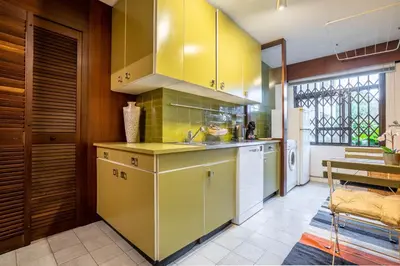 a kitchen with yellow cabinets and a sink at Casa Jardim by LovelyStay in Porto