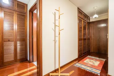 a walk in closet with wooden doors and a rug at Casa Jardim by LovelyStay in Porto