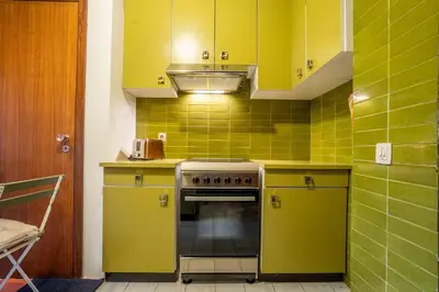 a kitchen with yellow cabinets and an oven at Casa Jardim by LovelyStay in Porto