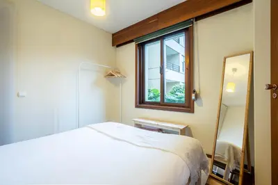 a bedroom with a bed and a window and a mirror at Casa Jardim by LovelyStay in Porto