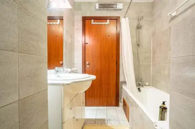 a bathroom with a sink and a wooden door at Casa Jardim by LovelyStay in Porto