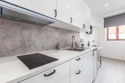 a kitchen with white cabinets and a sink at Studio de luxo no Porto - T0 in Porto
