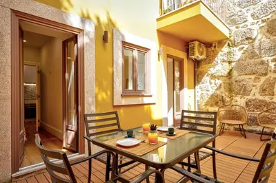a glass table and chairs on a porch with a table and chairs at Cais das Pedras Terrace by Cozy Stay in Porto