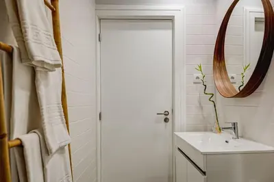 a white bathroom with a sink and a mirror at Cais das Pedras Terrace by Cozy Stay in Porto
