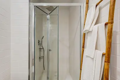 a glass shower stall in a bathroom with white towels at Cais das Pedras Terrace by Cozy Stay in Porto