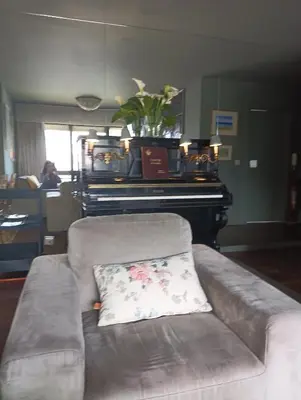 a couch with a pillow in a living room with a piano at Praceta in Porto
