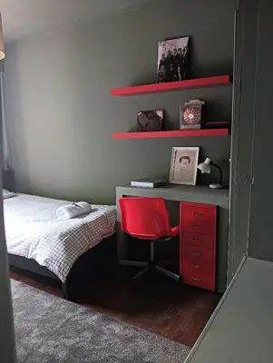 a bedroom with a bed and a desk with a red chair at Praceta in Porto