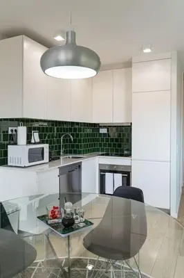 a kitchen with a glass table and a microwave at Lu's Douro View Apartment in Vila Nova de Gaia