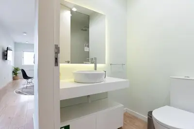 a white bathroom with a sink and a toilet at Lu's Douro View Apartment in Vila Nova de Gaia