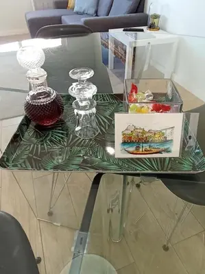 a glass table with glasses and a box on it at Lu's Douro View Apartment in Vila Nova de Gaia