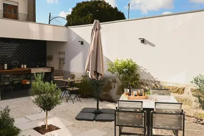 a patio with an umbrella and a table and chairs at Douro Premium Garden by MP in Vila Nova de Gaia