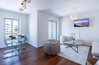 a living room with a table and a couch at Cedofeita Sunny Apartment - Balcony & Parking in Porto
