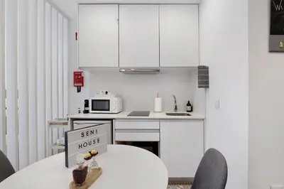 a kitchen with a table with a sign that says sell house at Seni's House in Porto