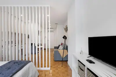 a bedroom with a bed and a flat screen tv at Seni's House in Porto