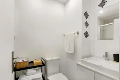 a white bathroom with a toilet and a sink at Seni's House in Porto