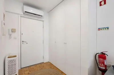 a room with white walls and a door with a heater at Seni's House in Porto