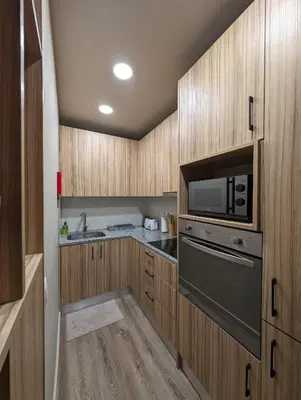 a kitchen with wooden cabinets and a microwave oven at BonJardim Apartment by Nove in Porto