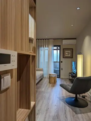 a living room with a chair and a bedroom at BonJardim Apartment by Nove in Porto